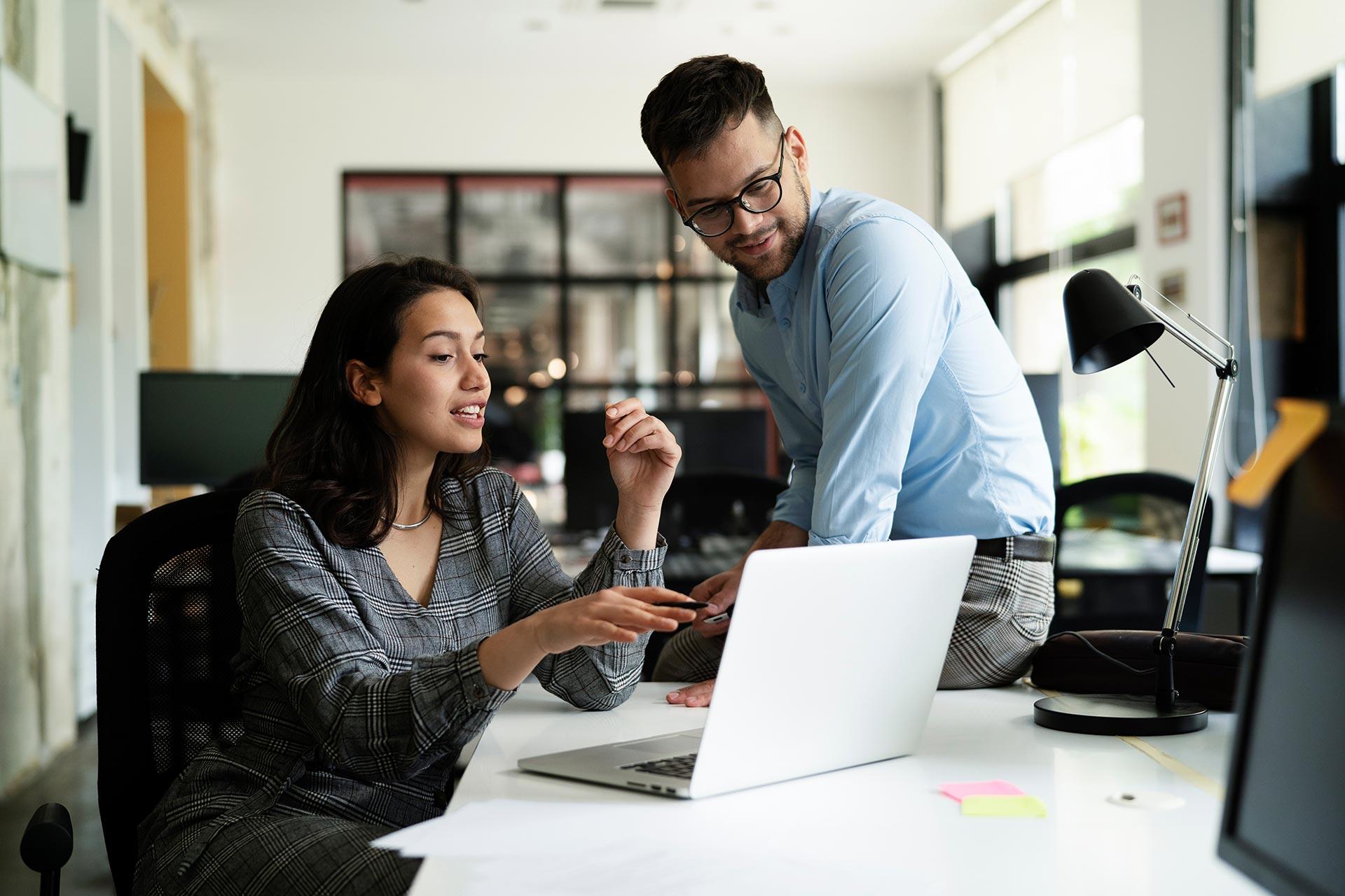 Businesswoman and Businessman Discussing Work in Office